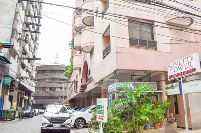 a building on a city street with cars parked outside at Sunette Tower Suites Makati City Center in Manila