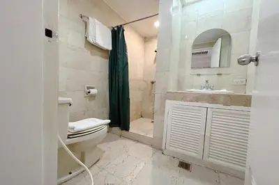 a bathroom with a toilet and a sink and a shower at Sunette Tower Suites Makati City Center in Manila