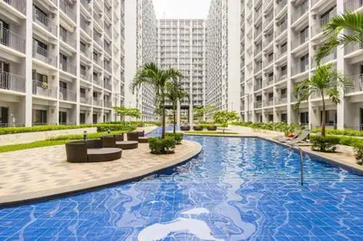 a large swimming pool in the middle of a building at Shore 2 Residences 1BR Deluxe Room in MOA Complex in Manila
