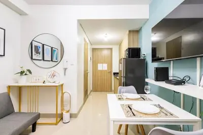 a small kitchen with a table and a room with a kitchen at Shore 2 Residences 1BR Deluxe Room in MOA Complex in Manila