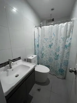 a bathroom with a toilet and a shower curtain at Canlubang Luxury Apartment in Canlubang