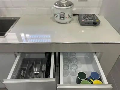 a kitchen counter with a drawer with dishes at Canlubang Luxury Apartment in Canlubang