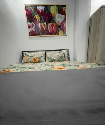 a bed in a bedroom with a painting on the wall at Canlubang Luxury Apartment in Canlubang