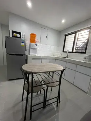 a small kitchen with a table and a refrigerator at Canlubang Luxury Apartment in Canlubang