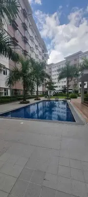 a swimming pool in front of a large apartment building at Auberge Condotels at SMDC Hope Residences in Trece Martires