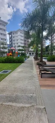 a park with benches and palm trees and buildings at Auberge Condotels at SMDC Hope Residences in Trece Martires
