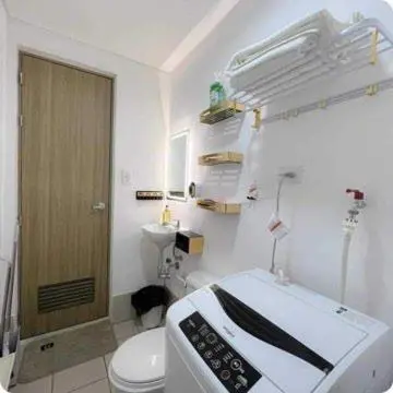 a bathroom with a microwave and a toilet at Auberge Condotels at SMDC Hope Residences in Trece Martires