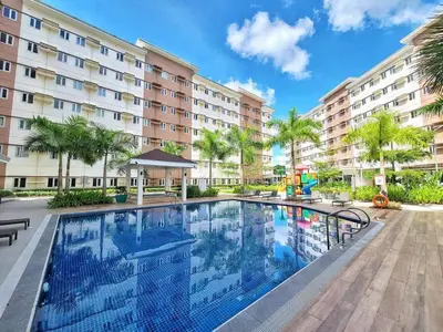a swimming pool in front of a building at Auberge Condotels at SMDC Hope Residences in Trece Martires