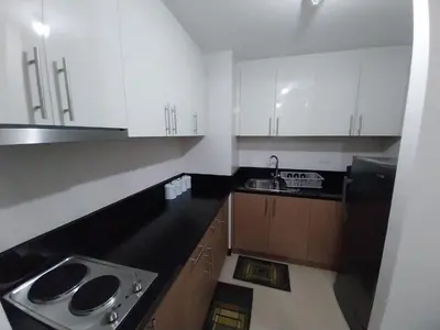 a kitchen with white cabinets and a sink at Alps Guesthouse at 150 Newport Blvd near T3 in Manila