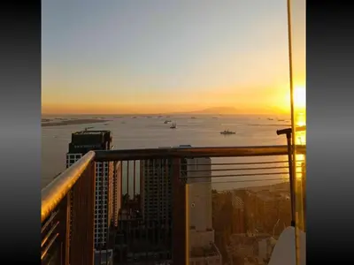 a sunset from the balcony of a skyscraper at Near US Embassy x Free Unlimited POOL, MASSAGE & SAUNA Access x Promo This Month! Explore Deluxe Studio w Balcony in Manila Perfectly Situated Near NAIA Airport, Heart of Manila Updated 2025 Price for Your Unforgettable Ultimate Staycation Experience in Manila