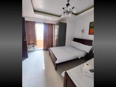 a bedroom with two beds and a table in it at Near US Embassy x Free Unlimited POOL, MASSAGE & SAUNA Access x Promo This Month! Explore Deluxe Studio w Balcony in Manila Perfectly Situated Near NAIA Airport, Heart of Manila Updated 2025 Price for Your Unforgettable Ultimate Staycation Experience in Manila