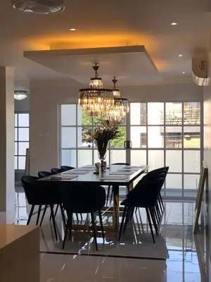 a dining room table with chairs and a chandelier at Luxury 4 Bedroom Apartment in San Andres