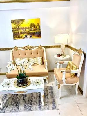 a living room with a couch and two chairs at RK Maisson Roiyale Pasig in Manila