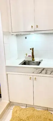 a kitchen with white cabinets and a sink at RK Maisson Roiyale Pasig in Manila