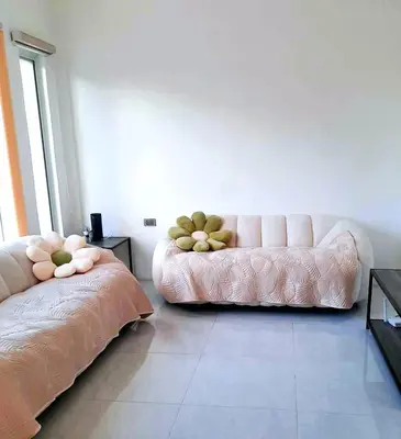 a living room with a pink couch in the corner at Mountain View in Binangonan