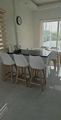 a dining room with a table and chairs and a clock at Mountain View in Binangonan