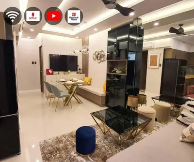 a living room with a table and a dining room at Stylish 2 Bedroom Condo Near BGC and Airport with Fast WiFi in Manila