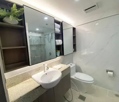 a white bathroom with a sink and a toilet at Stylish 2 Bedroom Condo Near BGC and Airport with Fast WiFi in Manila