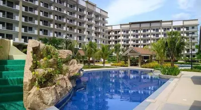 a swimming pool in front of a large building at Stylish 2 Bedroom Condo Near BGC and Airport with Fast WiFi in Manila