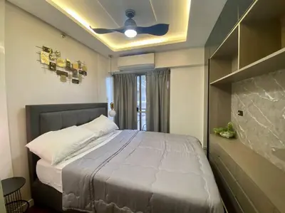 a bedroom with a large bed with a ceiling fan at Stylish 2 Bedroom Condo Near BGC and Airport with Fast WiFi in Manila