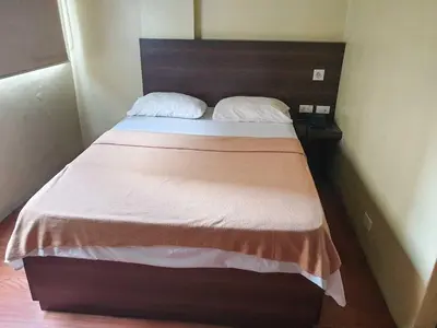 a bedroom with a bed with a wooden head board at OYO 1011 First Hotel in Manila