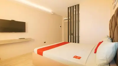 a bedroom with a bed and a flat screen tv at RedDoorz Plus at Seventy Five Inn Near Manila Airport in Manila