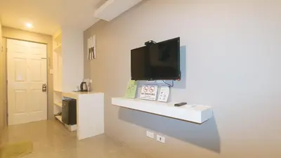 a living room with a tv on a wall at RedDoorz Plus at Seventy Five Inn Near Manila Airport in Manila