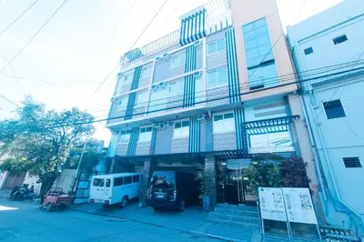 a building with a van parked in front of it at RedDoorz Plus at Seventy Five Inn Near Manila Airport in Manila