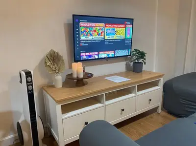 a flat screen tv on top of a white dresser at Bohemian Inspired 2 Bedroom Inspired Condo with Fast WIFI Near BGC in Manila