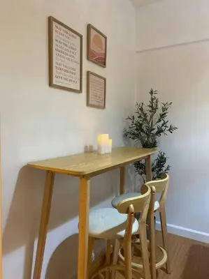 a wooden table with two chairs and a table with candles at Bohemian Inspired 2 Bedroom Inspired Condo with Fast WIFI Near BGC in Manila
