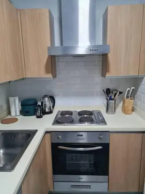 a kitchen with a stove and a sink at Homey condo unit in BGC - B SOMA NT in Manila