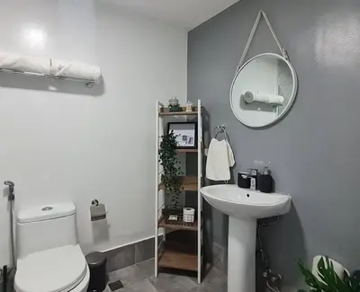 a bathroom with a toilet and a sink and a mirror at Homey condo unit in BGC - B SOMA NT in Manila