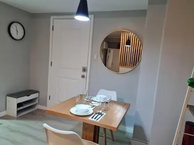 a dining room with a table and a mirror at Homey condo unit in BGC - B SOMA NT in Manila