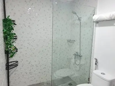 a glass shower in a bathroom with a toilet at Homey condo unit in BGC - B SOMA NT in Manila