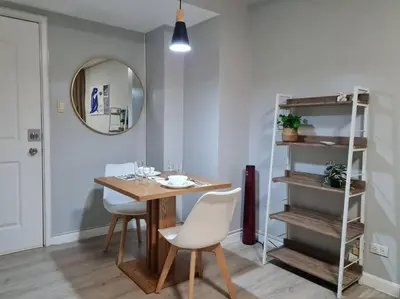 a dining room with a table and chairs and a mirror at Homey condo unit in BGC - B SOMA NT in Manila