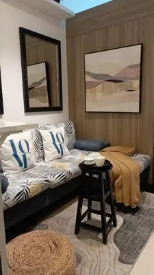 a living room with a couch and a table at Cozy New 1BR Fame Residences Condo with Balcony in Manila