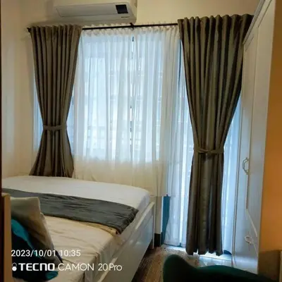 a bedroom with a bed and a window with curtains at Cozy New 1BR Fame Residences Condo with Balcony in Manila