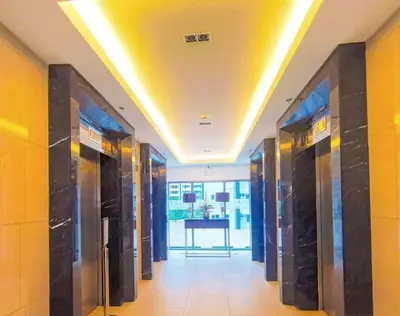 a hallway with a row of elevators in a building at Cozy New 1BR Fame Residences Condo with Balcony in Manila