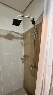 a shower with a shower head in a bathroom at CozyCoastStay by APPLETRAVELBEYONDPH in Manila