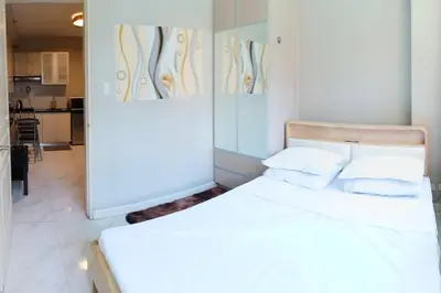 a bedroom with a white bed with two pillows at Monarch Parksuites - Balmoral Place (near NAIA, MOA, MOA Arena, DFA) in Manila