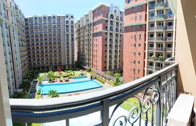 a balcony with a pool and some buildings at Monarch Parksuites - Balmoral Place (near NAIA, MOA, MOA Arena, DFA) in Manila