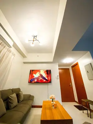 a living room with a couch and a table at Deluxe Room w/ Pool & Billiards in Manila