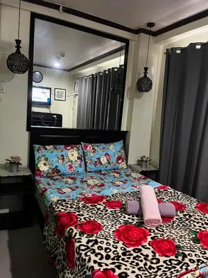 a bedroom with a bed with red roses on it at V&J Transient Condotel in Manila