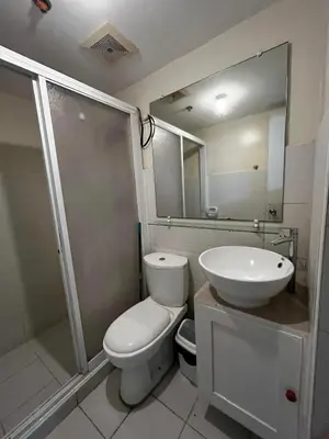 a bathroom with a toilet and a sink and a shower at V&J Transient Condotel in Manila