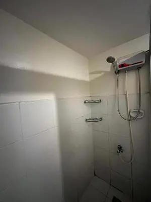 a white bathroom with a shower with a hose at V&J Transient Condotel in Manila