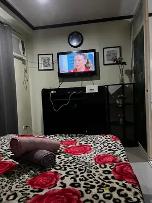 a bedroom with a bed with a television on the wall at V&J Transient Condotel in Manila