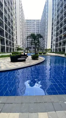 a large blue pool in a city with tall buildings at Stay COZY and BOUJEE in Manila