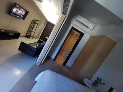 a view of a living room with a bed and a television at Caleze Properties Uptown Palazzo BGC One Bedroom in Manila