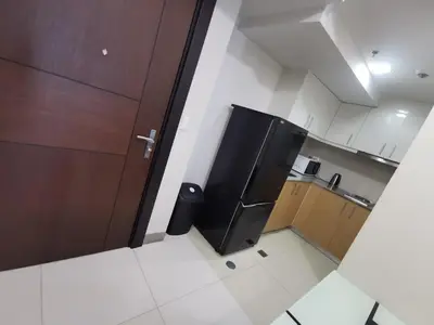 a small kitchen with a black refrigerator in it at Caleze Properties Uptown Palazzo BGC One Bedroom in Manila