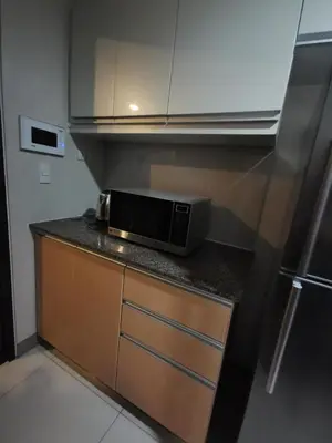 a microwave sitting on top of a counter in a kitchen at Caleze Properties Uptown Palazzo BGC One Bedroom in Manila